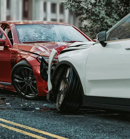 A red car and a white car have collided on a street, showing significant front-end damage. The scene conveys urgency and aftermath, with debris scattered.